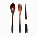 Wooden spoon, fork, and chopsticks with black accents on a white background