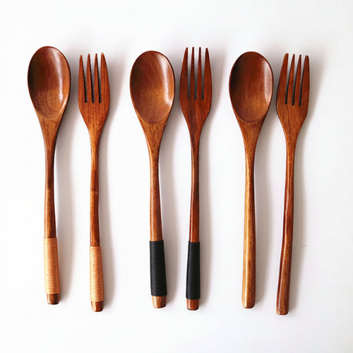 Set of wooden spoons and forks on a white background