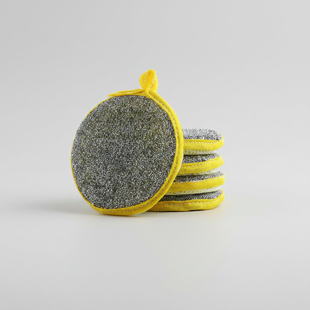 Set of gray scrubber pads with yellow handles on a white background