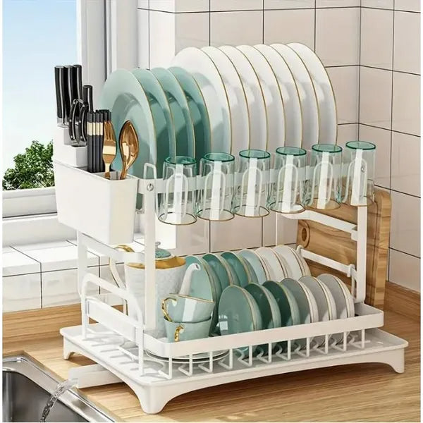 White dish rack with plates, glasses, and cups on a kitchen counter.