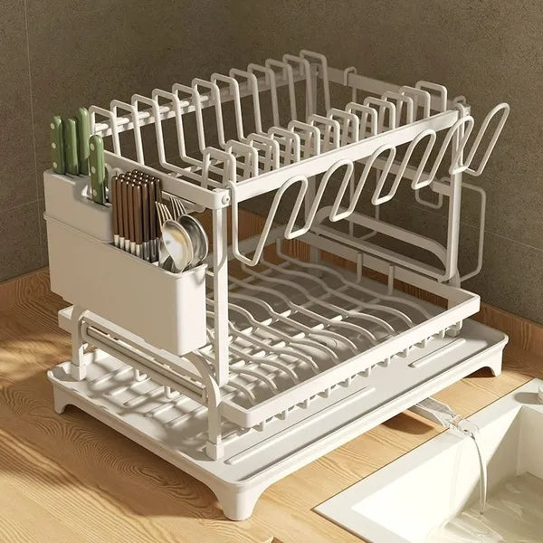 White dish drying rack with cutlery on a wooden countertop