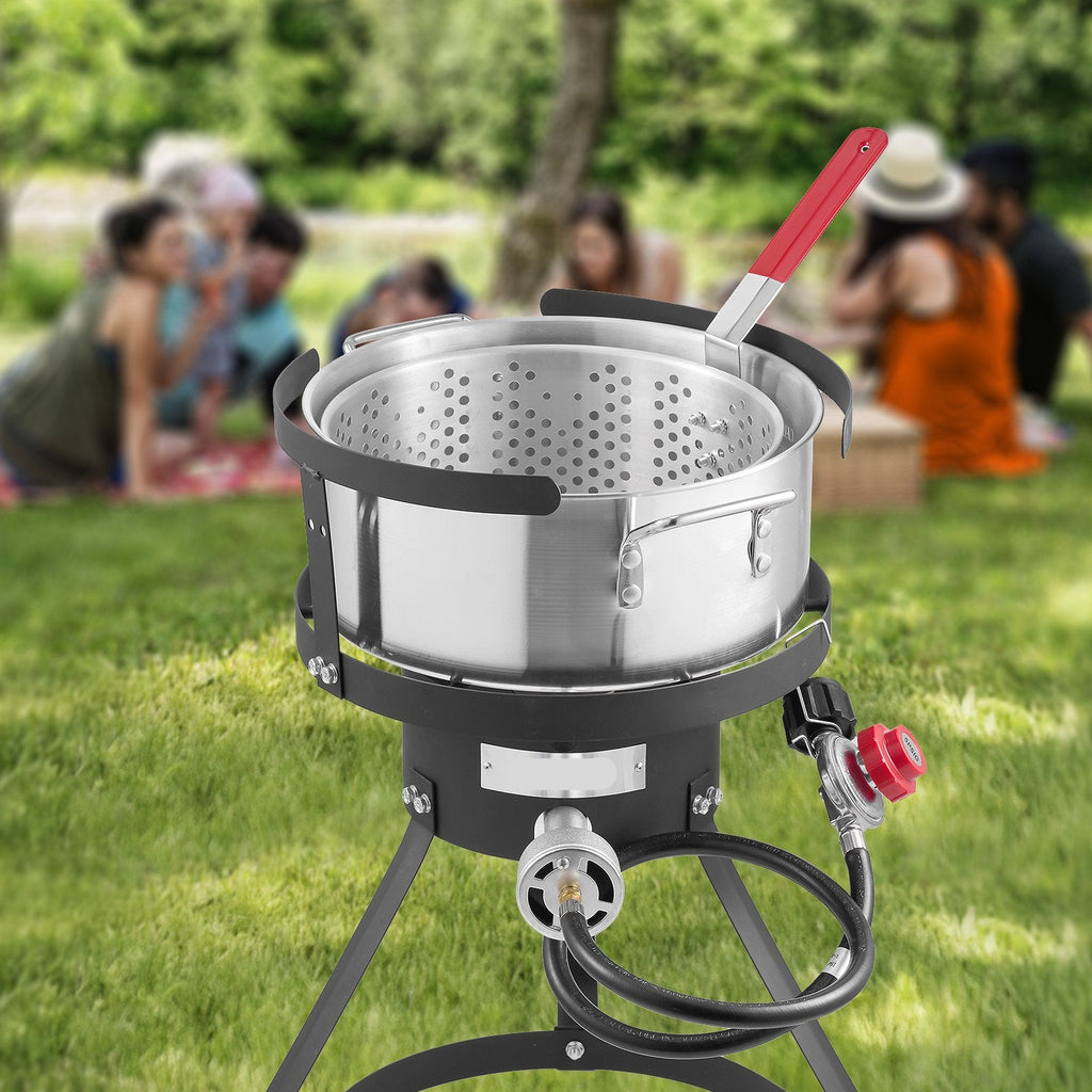 Portable stove with pot on a grassy outdoor setting